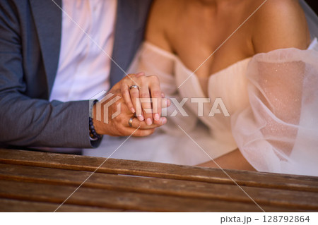 A Romantic Wedding Couple Holding Hands in Their Elegant Attire, Radiating Joy and Love 128792864
