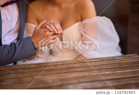 A Romantic Wedding Couple Holding Hands in Their Elegant Attire, Radiating Joy and Love 128792865