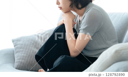 リビングのソファに座って考える女性 128792890