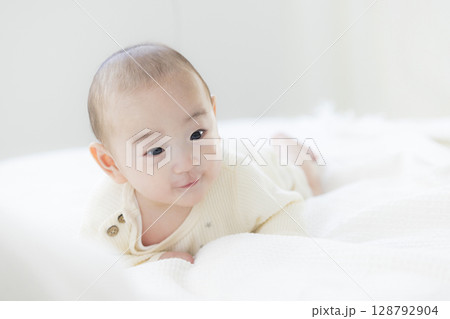 ベッドに寝転ぶ赤ちゃん ベッドに寝転ぶ赤ちゃん 128792904