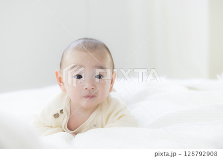ベッドに寝転ぶ赤ちゃん　 128792908