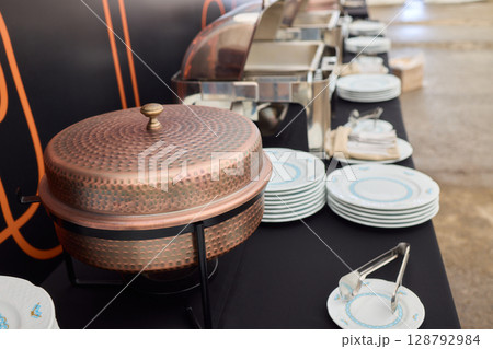 An Elegant Dining Setup Featuring a Silver Cloche and a Unique, Sophisticated Ambiance 128792984