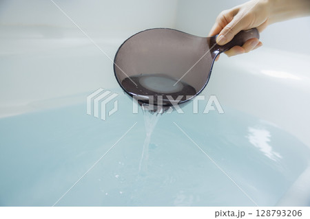 お湯を掬う女性の手 128793206