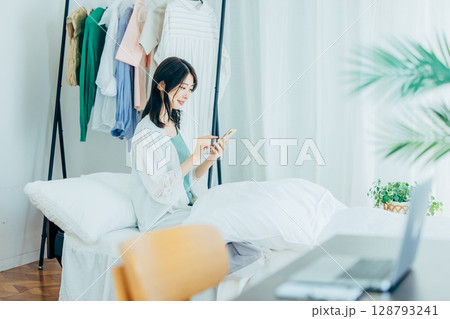 寝室でスマホを使う女性 寝室でスマホを使う女性 128793241