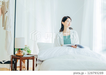 ベッドの上で雑誌を読む女性 128793289