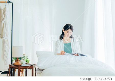 ベッドの上で雑誌を読む女性 128793294