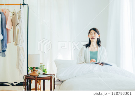 ベッドの上で雑誌を読む女性 ベッドの上で雑誌を読む女性 128793301