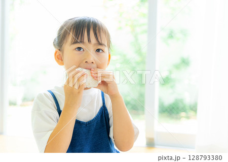 おにぎりを食べる女の子 128793380