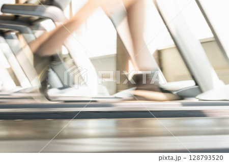 Mans legs running on treadmill in modern gym. Motion blur legs show speed and intensity. Workout session. Abstract sport background. Close up. 128793520