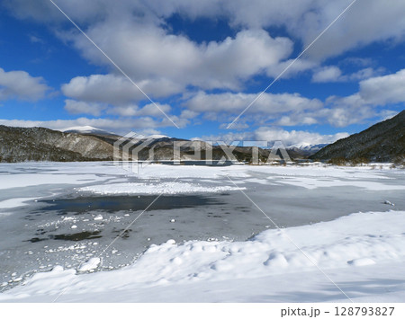 冬の裏磐梯、秋元湖。半凍結した湖面に雪が積もり、遠方には冠雪の吾妻山や箕輪山が連なり、印象的で綺麗だ 冬の裏磐梯、秋元湖。半凍結した湖面に雪が積もり、遠方には冠雪の吾妻山や箕輪山が連なり、印象的で綺麗だ 128793827