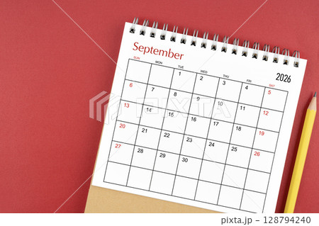 September 2026 desk calendar and pencil on red color background. 128794240