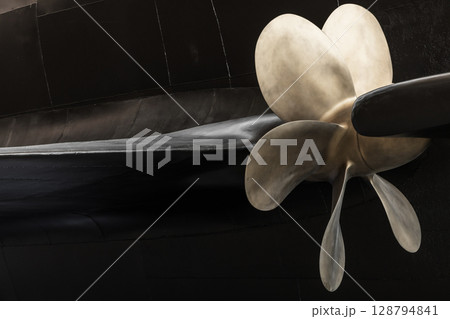 Ship Propeller Close-Up with Black Submarine Boat Hull Background Ship Propeller Close-Up with Black Submarine Boat Hull Background 128794841