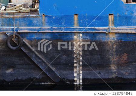 Close-Up View of a Rusty Ship Hull with Depth Scale Markers 128794845