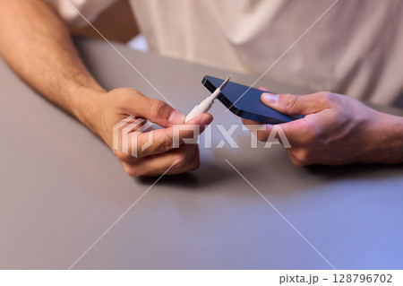 The Innovative Smartphone Cleaning Device is Being Demonstrated During Use and Functionality 128796702