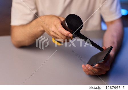 The Innovative Smartphone Cleaning Device is Being Demonstrated During Use and Functionality 128796745