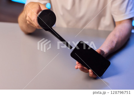 The Innovative Smartphone Cleaning Device is Being Demonstrated During Use and Functionality The Innovative Smartphone Cleaning Device is Being Demonstrated During Use and Functionality 128796751