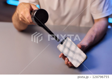 The Innovative Smartphone Cleaning Device is Being Demonstrated During Use and Functionality The Innovative Smartphone Cleaning Device is Being Demonstrated During Use and Functionality 128796755