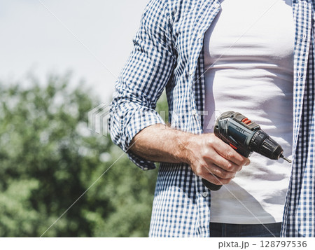 Handsome man, screwdriver and work clothes 128797536