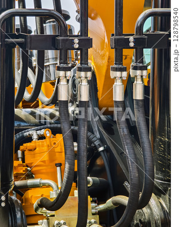 Hydraulic system components in heavy machinery showcasing intricate connections and detailing Hydraulic system components in heavy machinery showcasing intricate connections and detailing 128798540