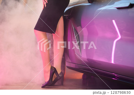 An Elegant Woman Gracefully Posing By a Luxury Car While Dressed in Chic and Stylish Attire An Elegant Woman Gracefully Posing By a Luxury Car While Dressed in Chic and Stylish Attire 128798630
