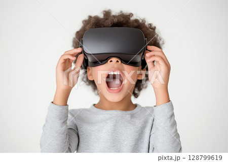 A close-up of a child wearing VR glasses, showing excitement and wonder 128799619