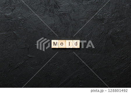 Mold word written on wood block. Mold text on table, concept 128801492