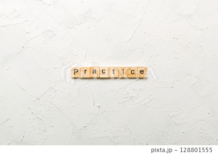 practice word written on wood block. practice text on table, concept 128801555