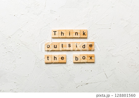 Think outside the box word written on wood block. Think outside the box text on cement table for your desing, Top view concept 128801560