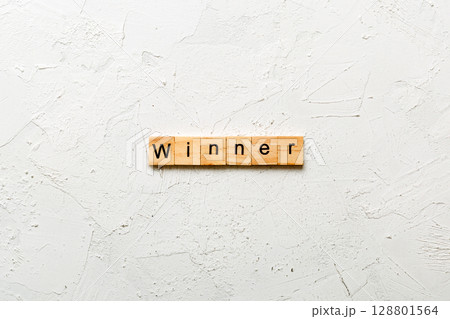 WINNER word written on wood block. WINNER text on cement table for your desing, concept 128801564