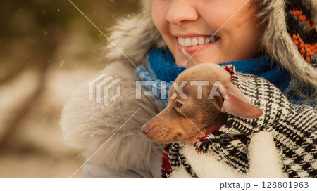 Woman hug warming her little dog in winter Woman hug warming her little dog in winter 128801963