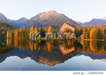Strbske pleso shines in autumn light among High Tatras peaks in Slovakia 128802049
