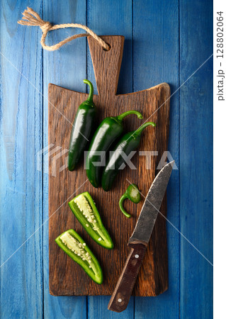 Whole and sliced green jalapeno hot peppers Whole and sliced green jalapeno hot peppers 128802064