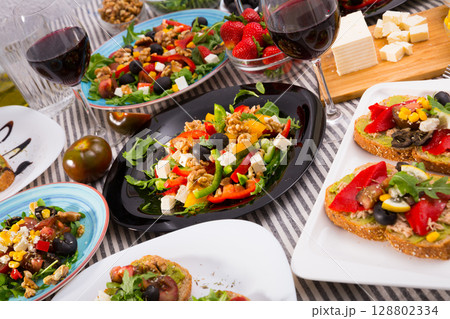 Many plates with tasty vegetarian food and wine in glass 128802334