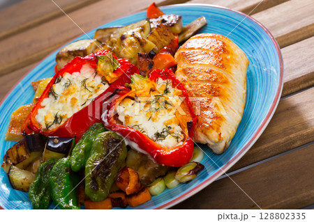 Delicious stuffed peppers with baked vegetables and chicken fillet 128802335
