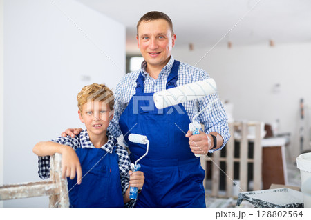 Boy with father holding renovating home tools Boy with father holding renovating home tools 128802564