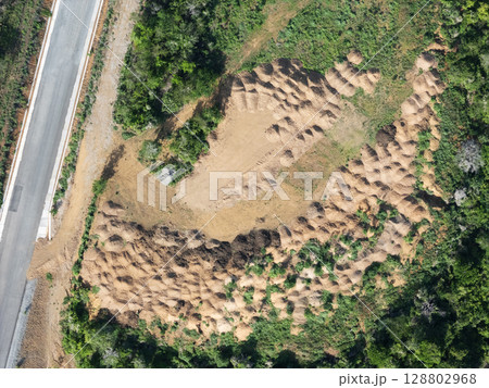 Landscape with mounds along roadside featuring earthworks in natural setting 128802968