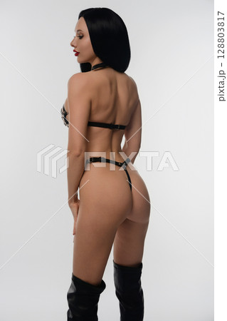 Woman showcasing stylish leather accessories in a studio setting 128803817