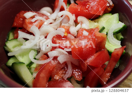 Cutted Fresh Cucumbers, Tomatoes And White Onion Sprinkled With Coarse Salt In A Salad Plate Closeup View Cutted Fresh Cucumbers, Tomatoes And White Onion Sprinkled With Coarse Salt In A Salad Plate Closeup View 128804637