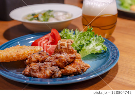 唐揚げと餃子スープ、ビールを添えた家庭の夕食 128804745
