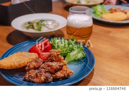 唐揚げと餃子スープ、ビールを添えた家庭の夕食 128804748