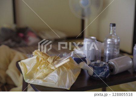ゴミが散乱した一人暮らしの部屋 128805518