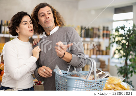 Husband and wife buying food in the supermarket 128805821