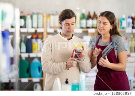 Female consultant helps man buyer choose razor Female consultant helps man buyer choose razor 128805957