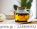 Transparent teapot with herbal tea brewing on table 128806932