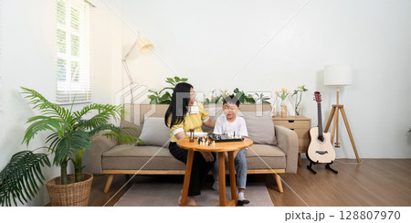 Family Bonding: Mother and Son Enjoying Chess Game at Home 128807970