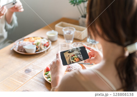 料理をスマホで撮影する手元 128808138