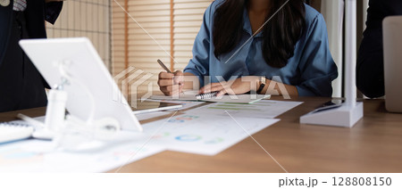 Focused Professional Taking Notes During ESG Strategy Meeting Focused Professional Taking Notes During ESG Strategy Meeting 128808150
