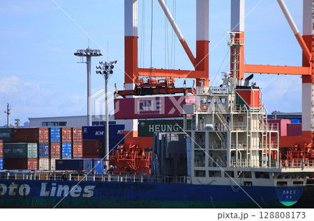 コンテナ埠頭に接岸する貨物船と荷役作業 コンテナ埠頭に接岸する貨物船と荷役作業 128808173
