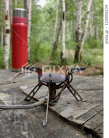 gas burner setup for cooking in serene forest during camping trip. closeup. gas burner setup for cooking in serene forest during camping trip. closeup. 128808234