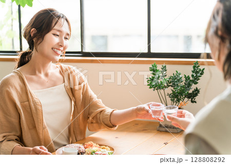 女子会で冷酒グラスで日本酒を飲む若いアジア人女性 128808292